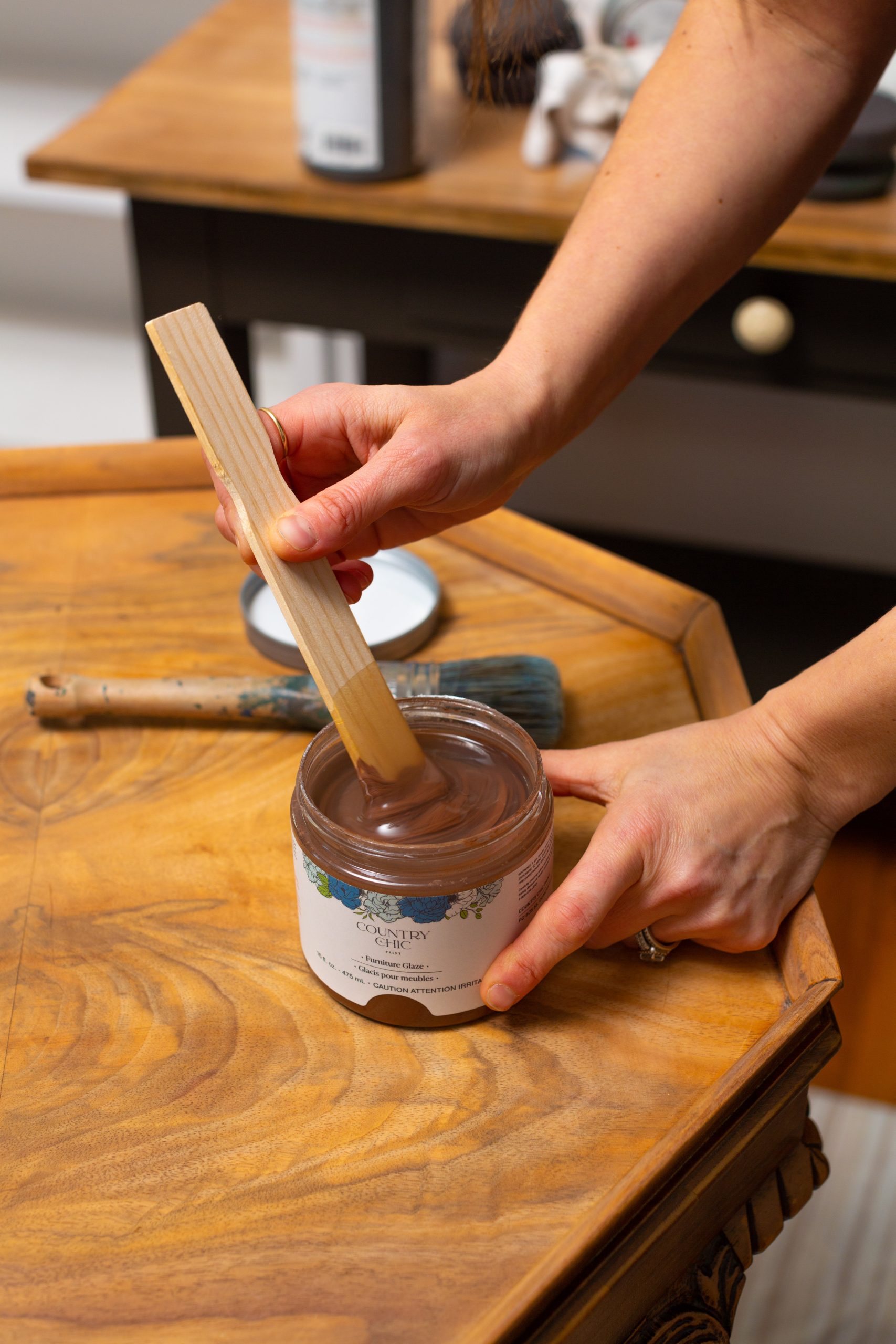 Stirring a jar of Tiger's Eye brown furniture glaze by Country Chic Paint