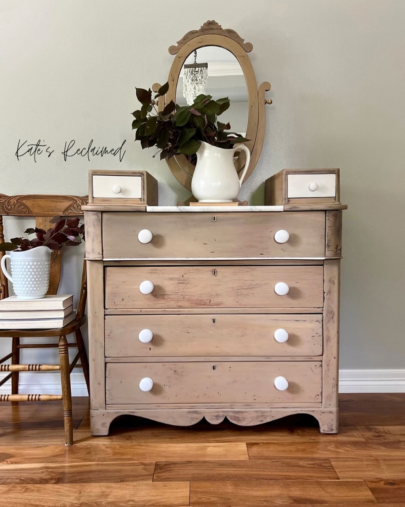 Brown paint washed wood dresser with white knobs and oval mirror