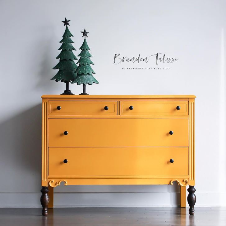 Mustard yellow painted dresser with christmas tree decor on top